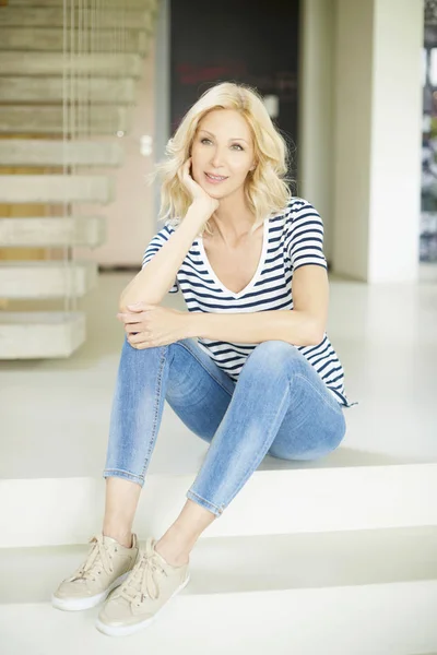 Woman sitting on modern stairs — Stock Photo, Image