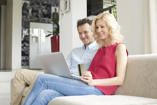 Couple using laptop and credit card — Stock Photo, Image