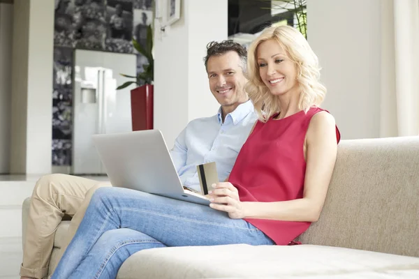 Casal usando laptop e cartão de crédito — Fotografia de Stock