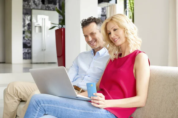 Casal usando laptop e cartão de crédito — Fotografia de Stock