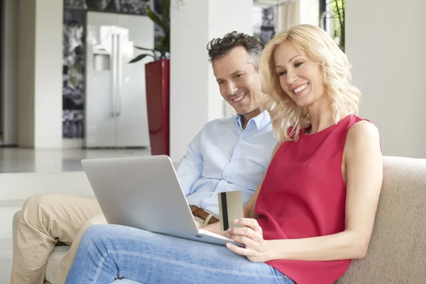 Couple using laptop and credit card — Stock Photo, Image
