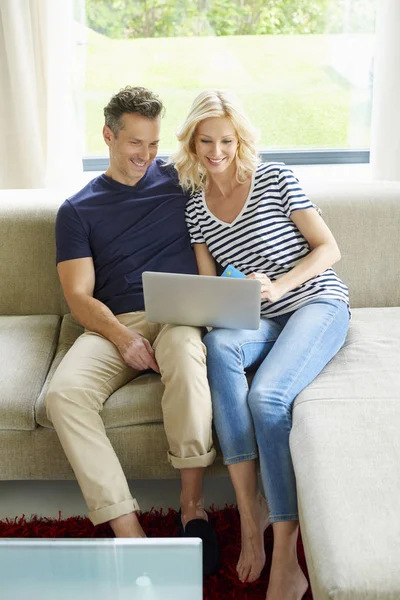 Casal usando laptop e cartão de crédito — Fotografia de Stock