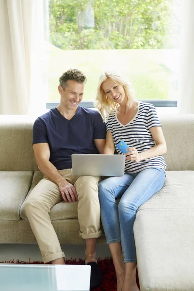Casal usando laptop e cartão de crédito — Fotografia de Stock