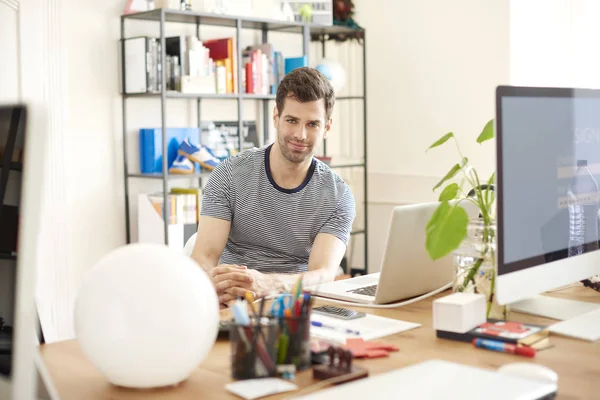 Kreatywnych mężczyzna siedzący przy biurku — Zdjęcie stockowe