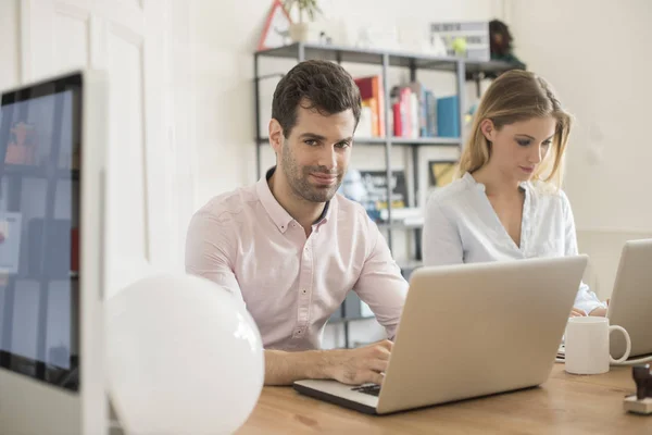 Compañeros de trabajo sentados en el escritorio — Foto de Stock