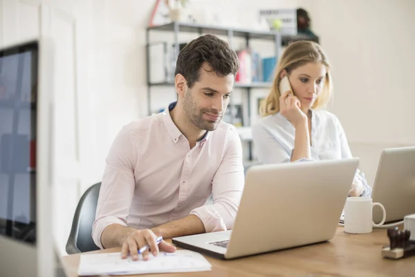 Collega's zitten aan balie — Stockfoto