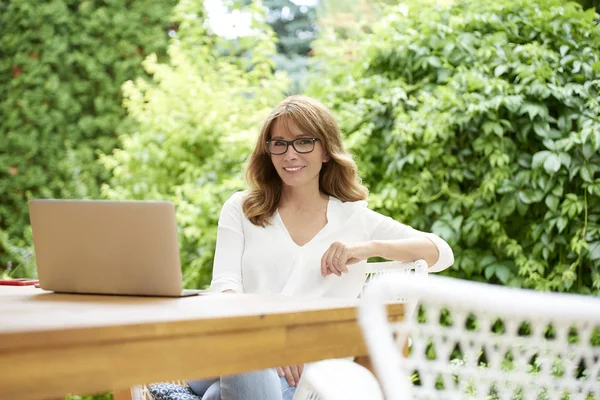 Frau benutzt Laptop im Sitzen — Stockfoto