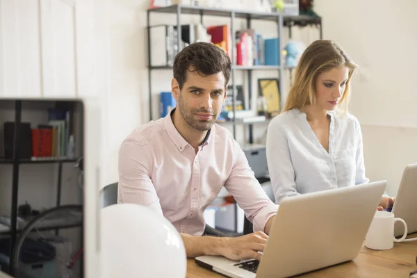 Compañeros de trabajo sentados en una mesa — Foto de Stock