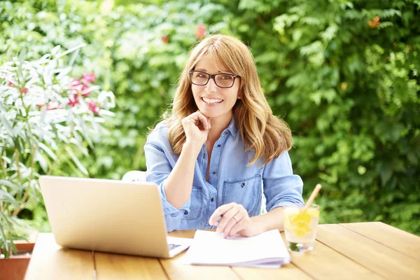 Kvinna med laptop medan du arbetar — Stockfoto