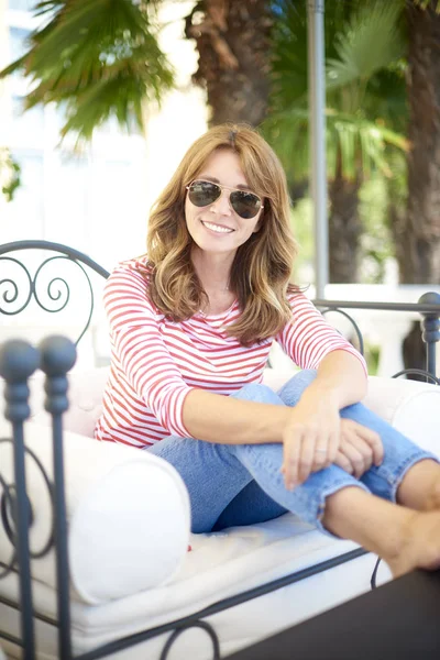 Mujer sonriente relajándose en el sofá — Foto de Stock