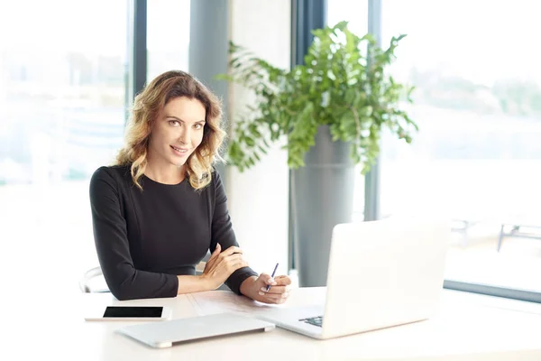 Affärskvinna som sitter med sin bärbara datorer — Stockfoto