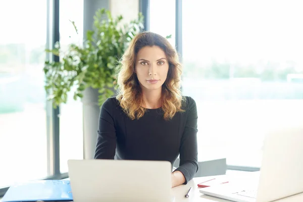 Affärskvinna som sitter vid skrivbord — Stockfoto