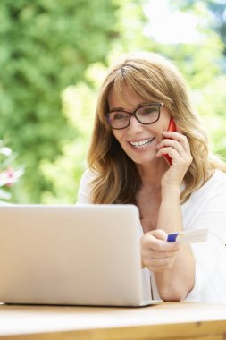 telefon ve banka kartı kullanan kadın