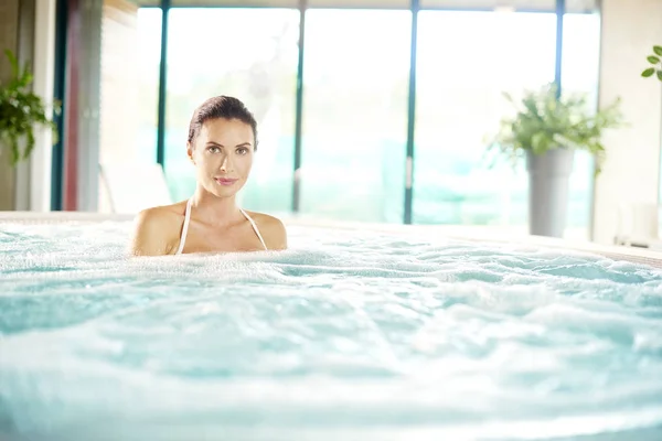 Kobieta relaksując się w jacuzzi — Zdjęcie stockowe