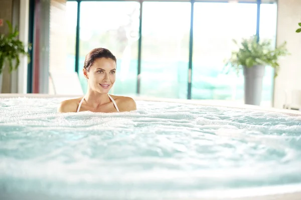 Mulher relaxante no jacuzzi . — Fotografia de Stock