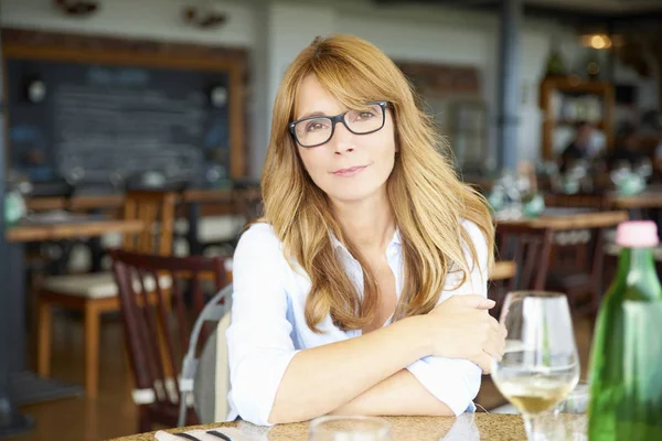 Stolze Frau sitzt am Tisch — Stockfoto