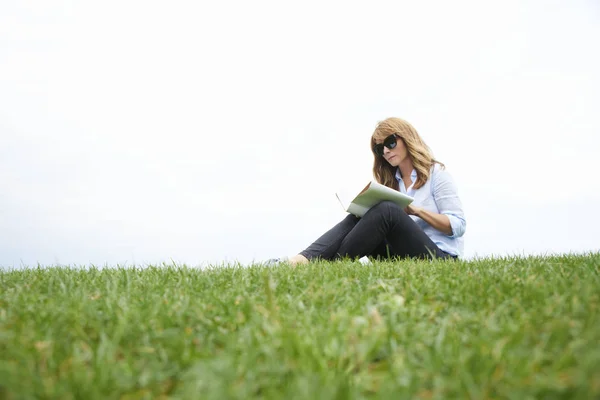 Frau entspannt sich mit einem guten Buch — Stockfoto