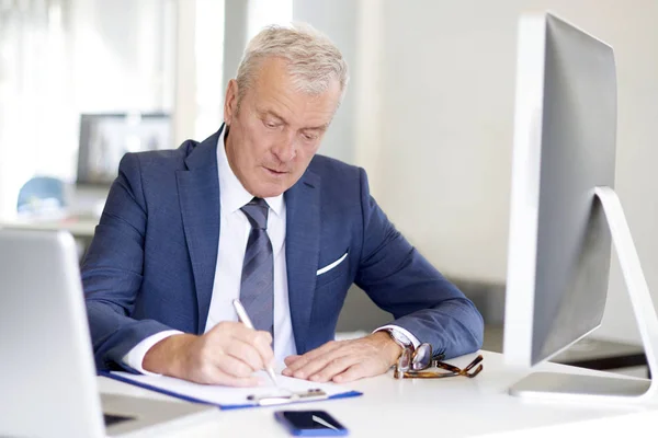 Empresario sentado en el escritorio —  Fotos de Stock