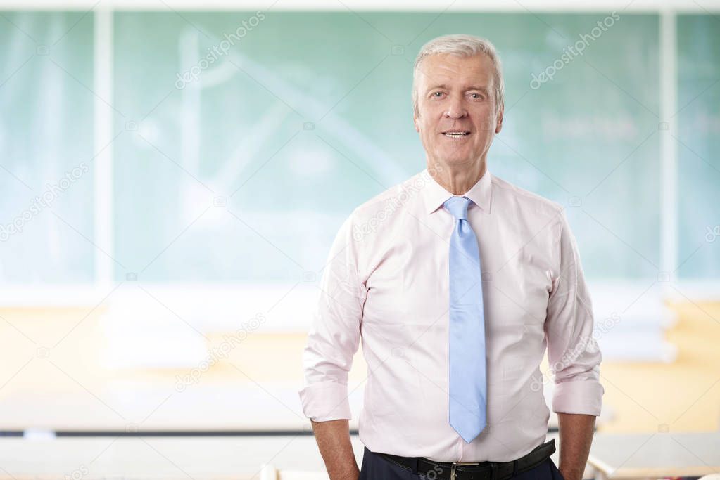 A senior male teacher standing 