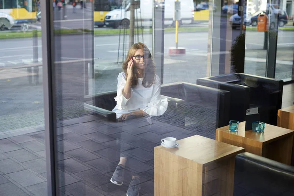 Mujer sentada detrás de una ventana de vidrio —  Fotos de Stock