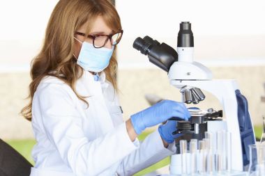 Mikroskop önünde oturma sırasında tıbbi laboratuvar test hazırlama bir çift orta yaşlı sağlık görevlisi.