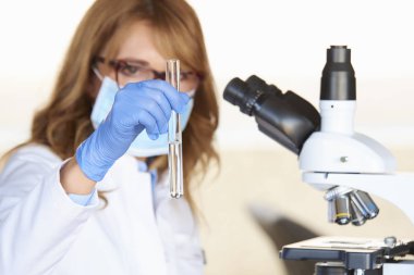 Mikroskop önünde oturma sırasında tıbbi laboratuvar test hazırlama bir çift orta yaşlı sağlık görevlisi.
