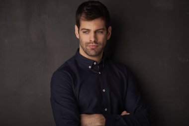 Silah ile ayakta düşünme genç adam koyu arka plan geçti.
