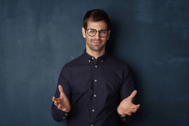 Kameraya bakarak genç gülümseyen bir adam 