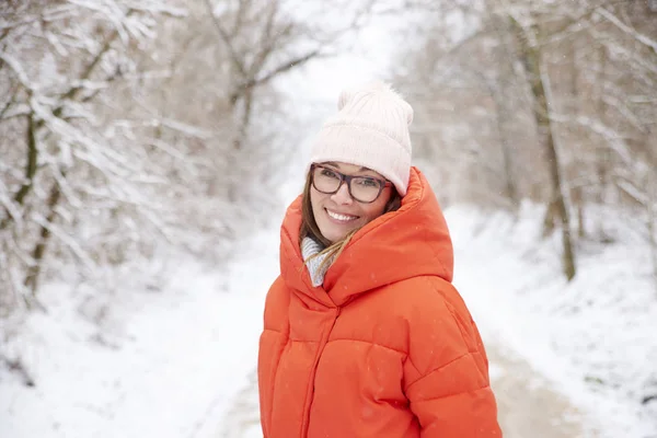 Женщина с зубастой улыбкой расслабляется на открытом воздухе зимой — стоковое фото