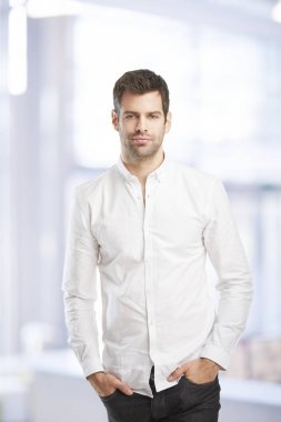 Gömlek giymiş ve kamera ofiste dururken bakarak genç mali asistanı iş adamı. 