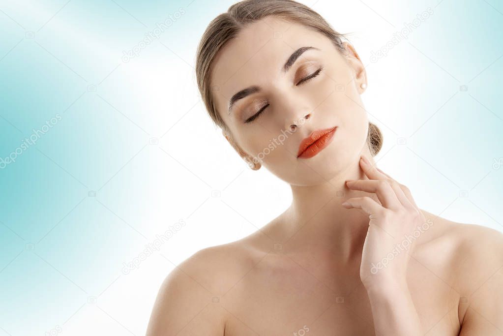 Relaxed young woman with closed eyes and beautiful face posing and isolated light blue background. 