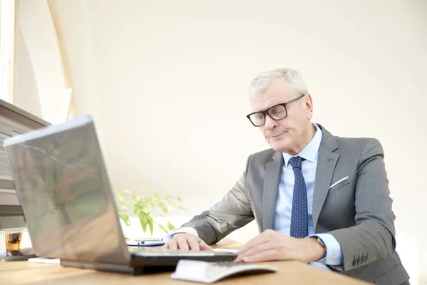 资深投资顾问商人穿着西装 坐在办公桌前工作 在笔记本电脑和计算财务数据的肖像 — 图库照片