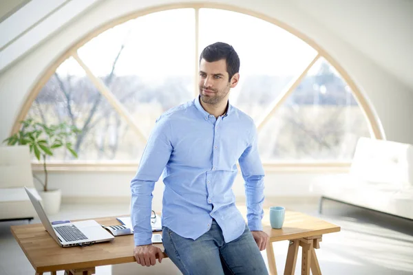 Retrato Jovem Empresário Casual Olhando Pensativo Enquanto Estava Mesa Escritório — Fotografia de Stock