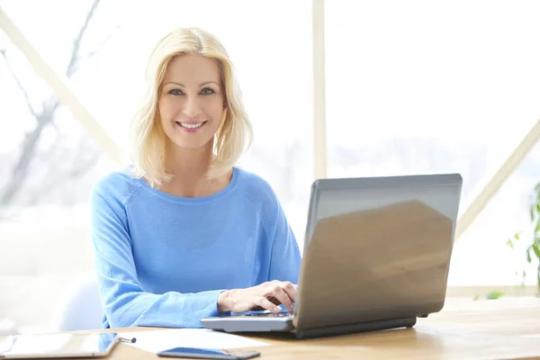Bonita Mulher Negócios Casual Meia Idade Sorridente Digitando Laptop Enquanto — Fotografia de Stock