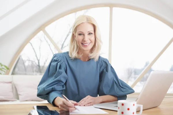 Smiling Blond Financial Assistant Businesswoman Writing Something While Sitting Desk — Stock Photo, Image