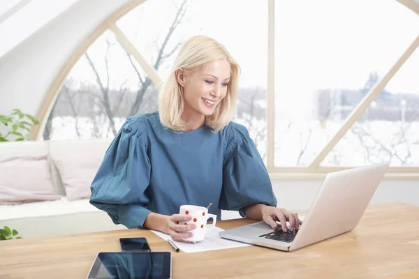 아름다운 금발의 사업가 사무실 책상에 새로운 프로젝트를 하면서 노트북으로 타자를 — 스톡 사진