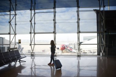 Kontrast yolcu terminal havaalanında bekliyor. Terminalde durmuş ve yatılı için bekleyen onun kabin Bagaj kadınla doz tam uzunlukta. 