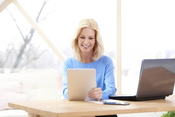 Mulher Negócios Meia Idade Sorrindo Usando Mesa Digital Enquanto Senta — Fotografia de Stock