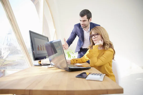 Geschäftsfrau Mittleren Alters Sitzt Schreibtisch Und Hält Ein Dokument Der — Stockfoto