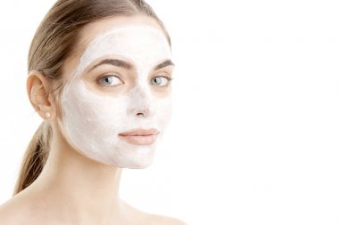 Yakın çekim çekim güzel bir genç kadının yüz maskesi giyiyor. Beyaz arka plan üzerinde izole.