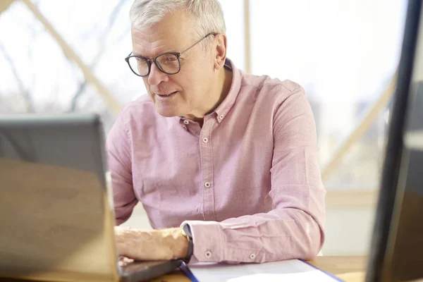 Hombre Jubilado Con Camisa Sentado Escritorio Mientras Trabaja Ordenador Portátil —  Fotos de Stock