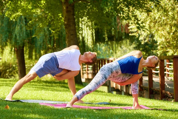 Passar par som gör yoga tillsammans utomhus — Stockfoto