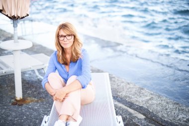 Güzel, olgun bir kadının güneşlendiği ve dinlendiği yüksek açılı bir çekim.. 