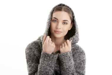 İzole edilmiş beyaz arka planda poz verirken kapüşonlu güzel bir genç kadının yakın çekim portresi..