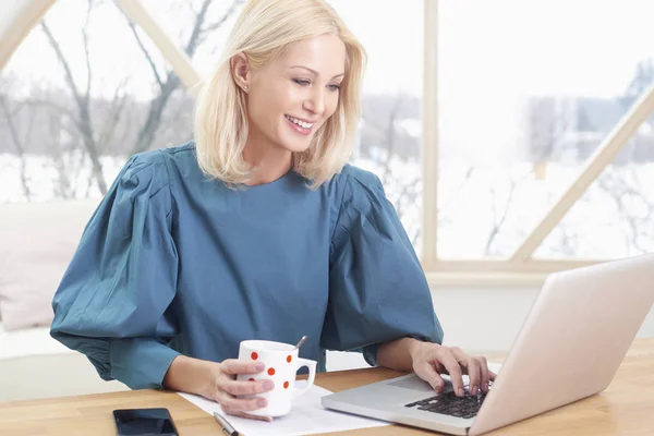 아름다운 금발의 사업가 사무실 책상에 새로운 프로젝트를 하면서 노트북으로 타자를 — 스톡 사진