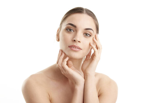 Cropped studio shot of a beautiful woman touching her face and looking at camera. Isolated at white background. 