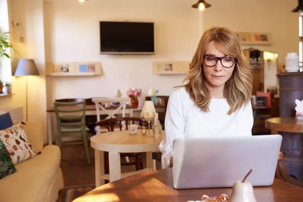 Foto Mujer Mediana Edad Sentada Escritorio Trabajando Cuaderno Pequeño Café — Foto de Stock