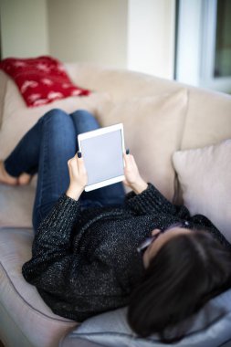 Arka planda, elinde boş ekranla elinde dijital tablet olan bir kadın var..