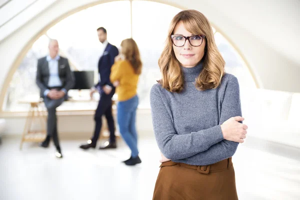 Confident middle aged businesswoman standing in the office — Stockfoto