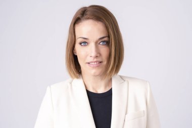 Ayrı beyaz arka planda dikilirken ofis kıyafeti giyen çekici orta yaşlı kadının yakın çekim portresi..